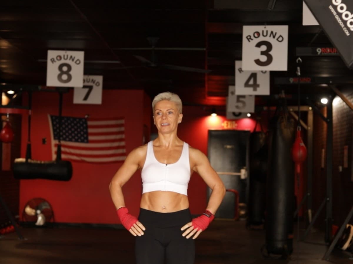Woman standing in a 9Rounds fitness boxing gym.