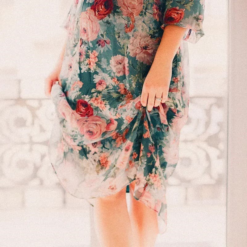 Woman standing on tip toes in dress.
