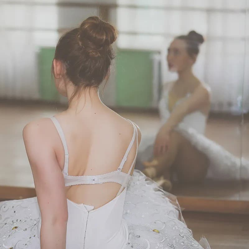 Ballerina stretching on the floor.