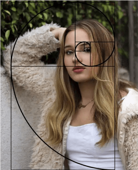 Girl wearing fur coat resting on wall with golden ratio.