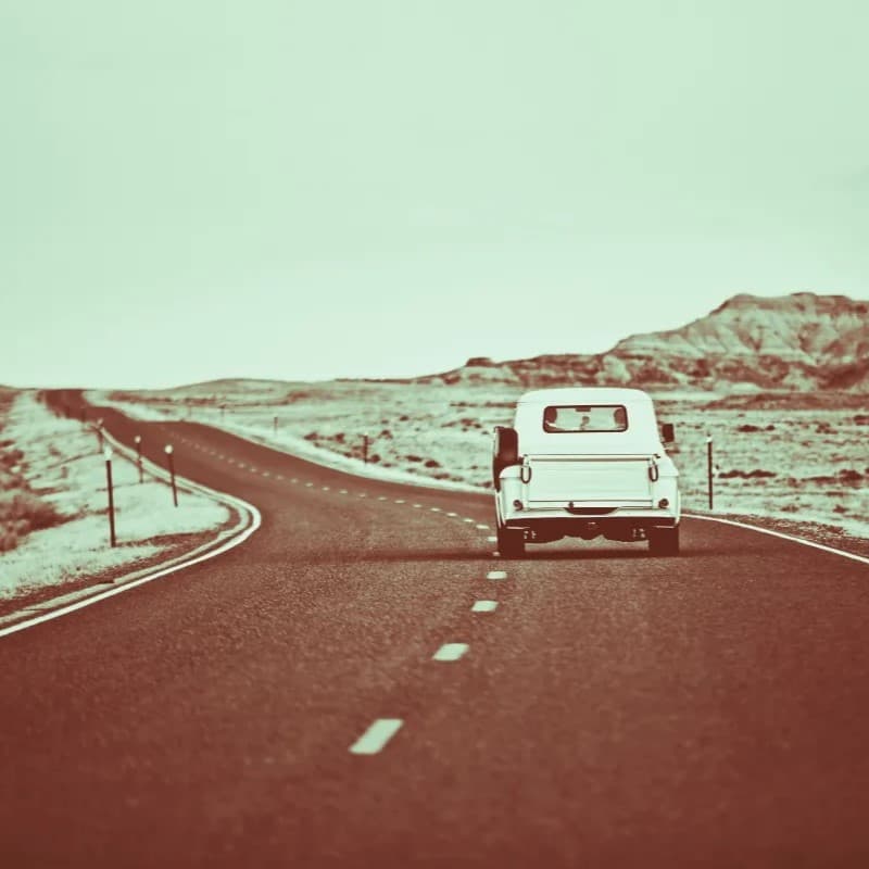 Car driving down empty road.