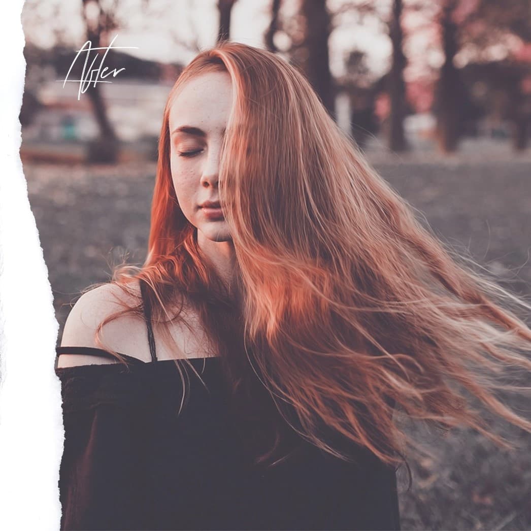 Red-haired woman eyes closed shaking her hair.