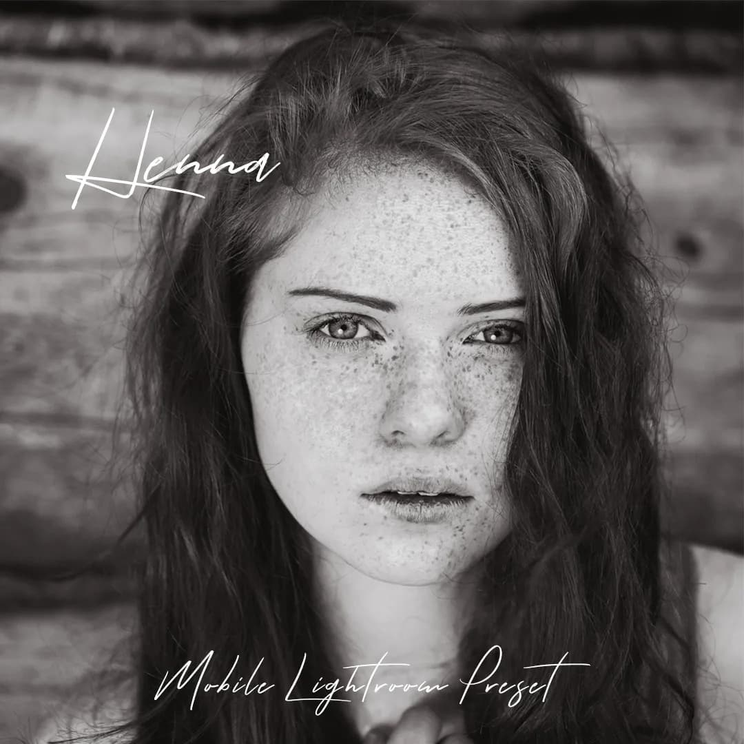 Freckled girl looking at camera in black and white.