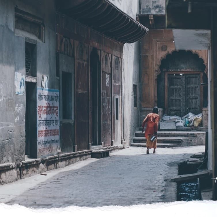 Older man walking down empty street.