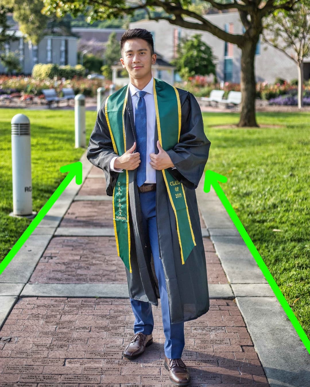 Man standing in graduation gown.