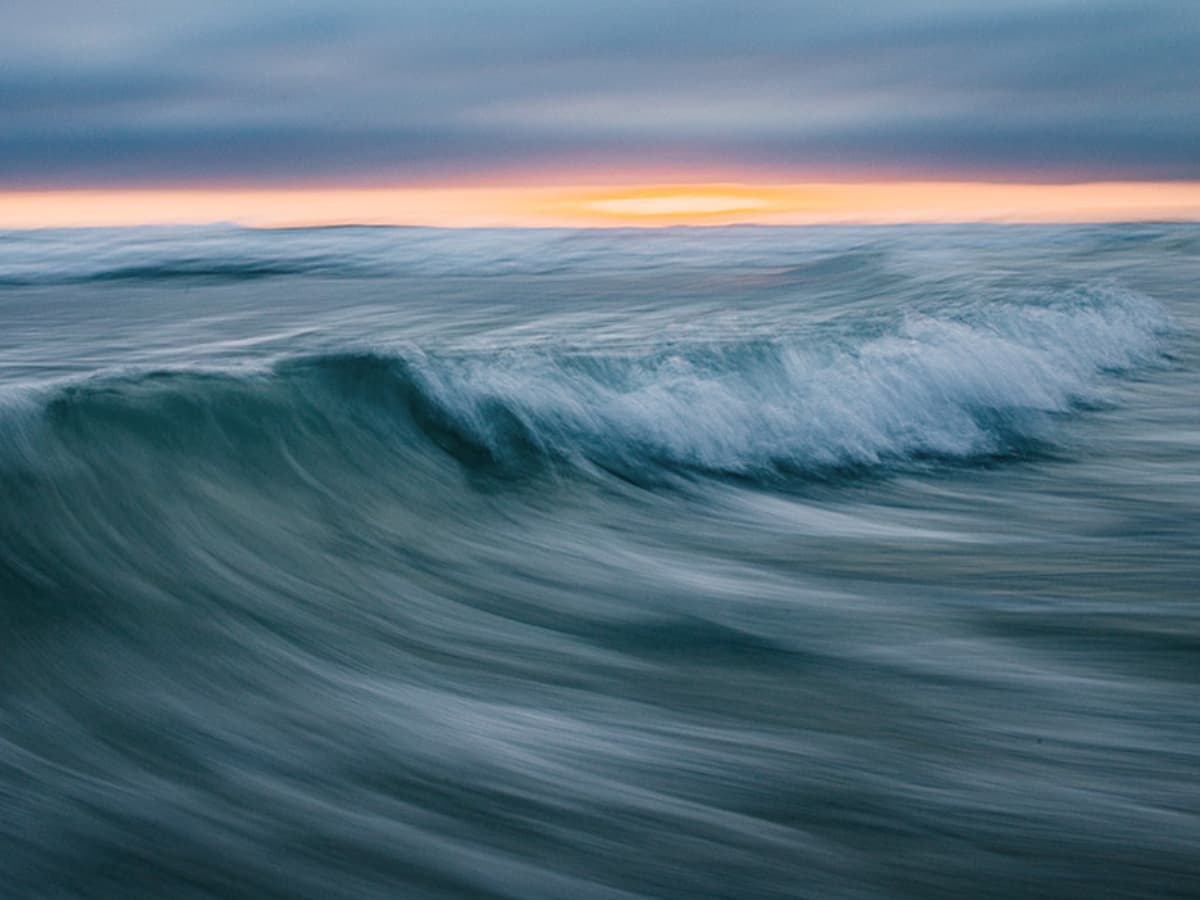 Blue waves with orange sunset.