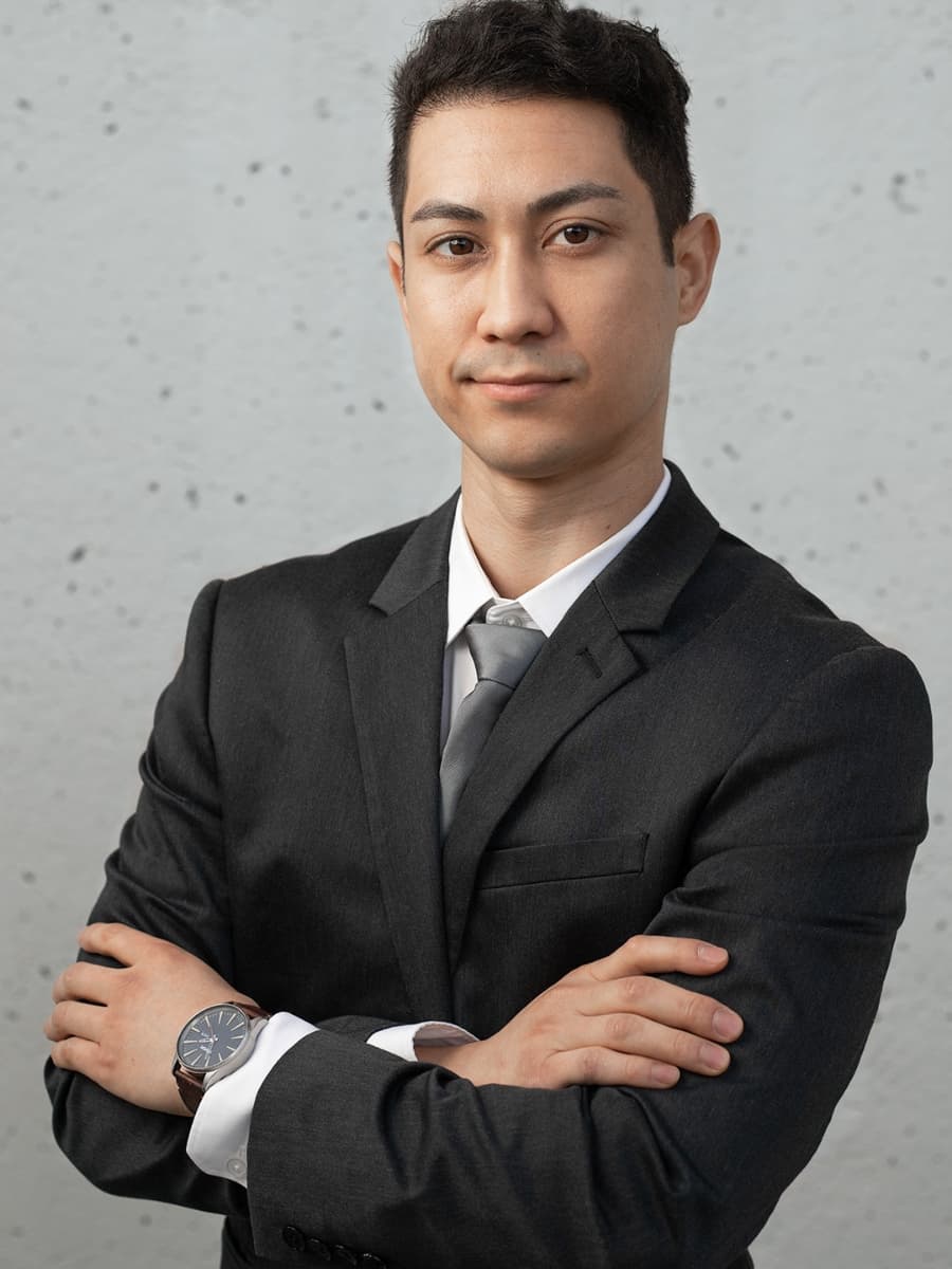 Man posing in suit with crossed arms.
