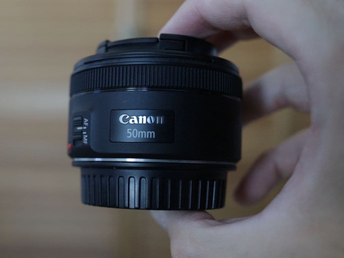 Holding the plastic lens body of the Canon EF 50mm f/1.8 in my hands.