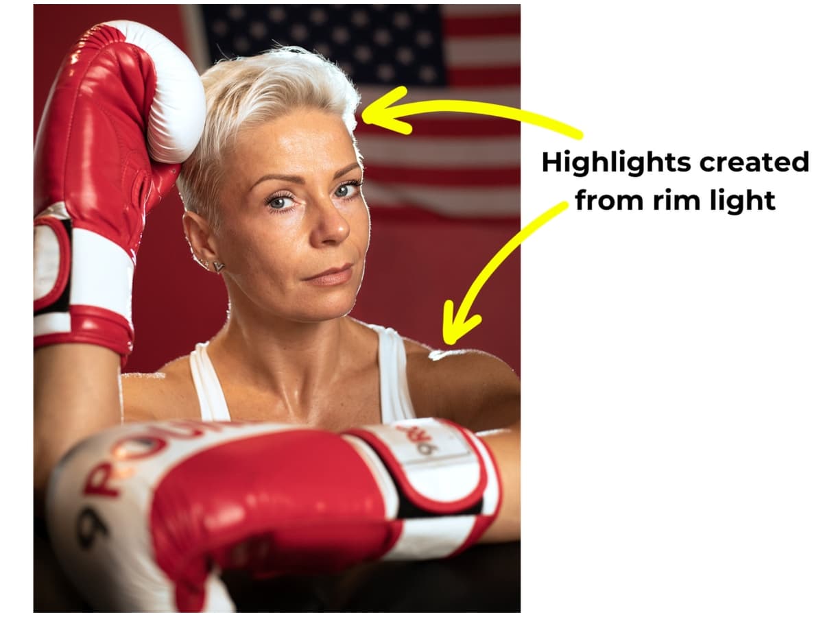 Highlights on model with boxing gloves face due to rim light.