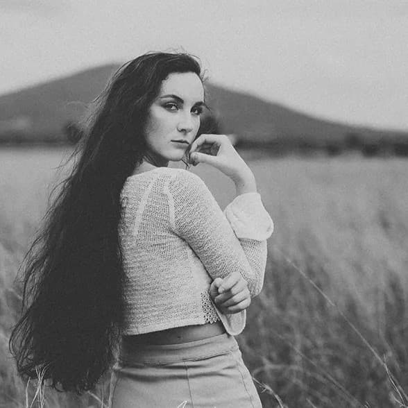 Woman looking over her shoulder in black and white.