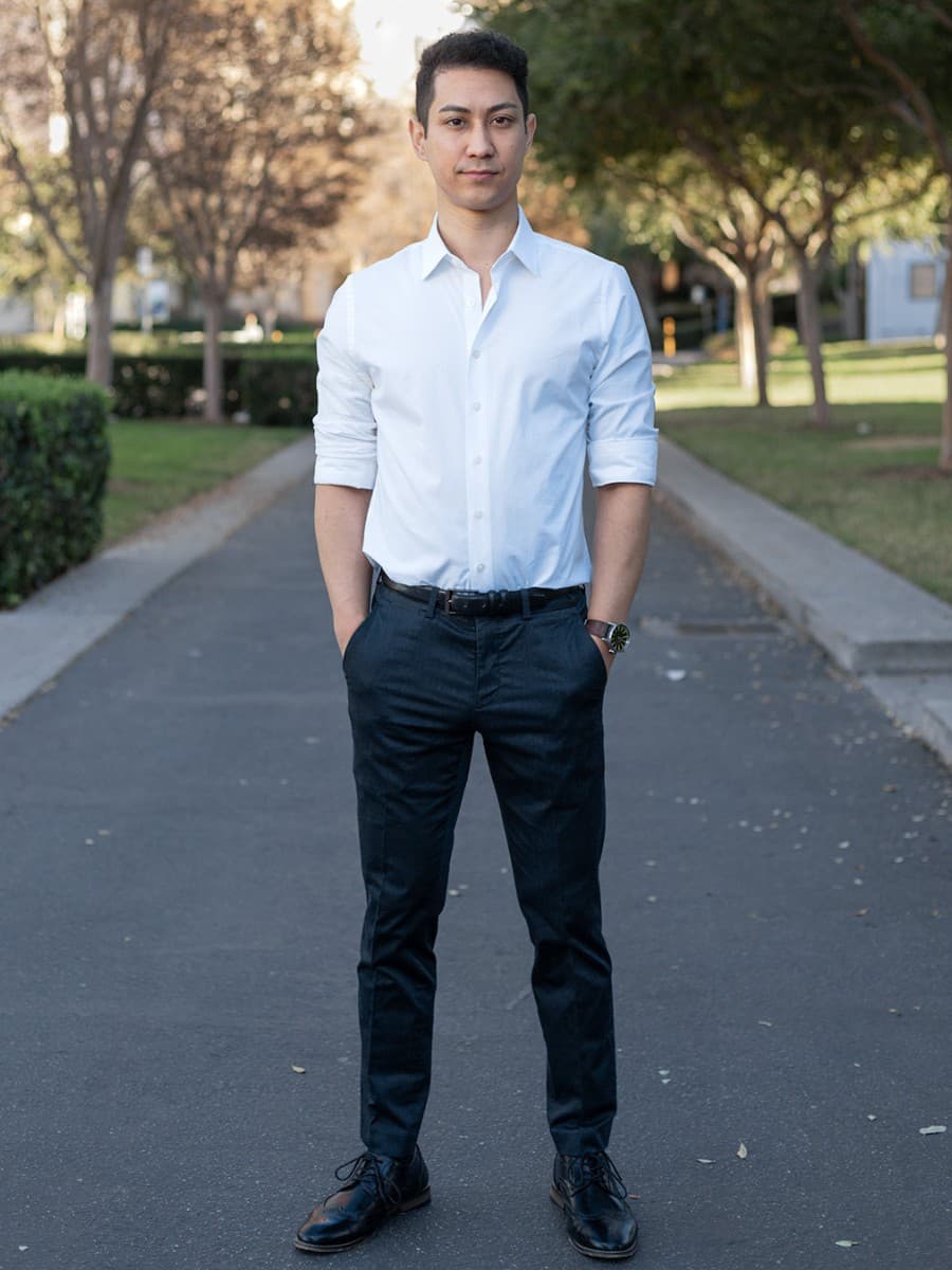 Man posing in street with both hands in pocket.