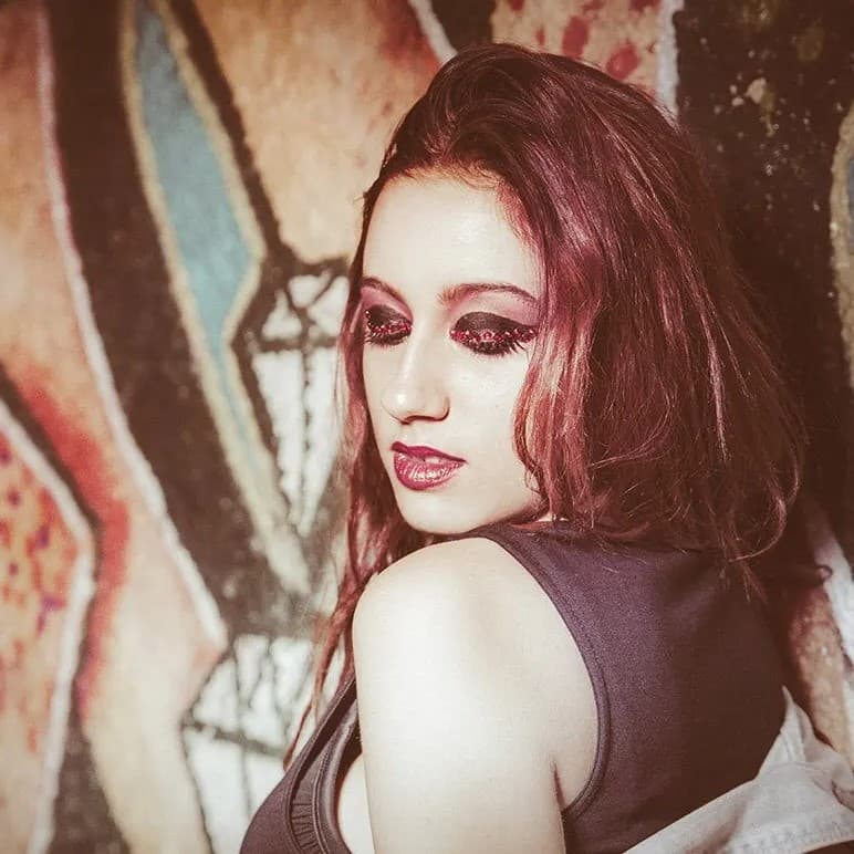 Woman looking over shoulder with eyes closed.