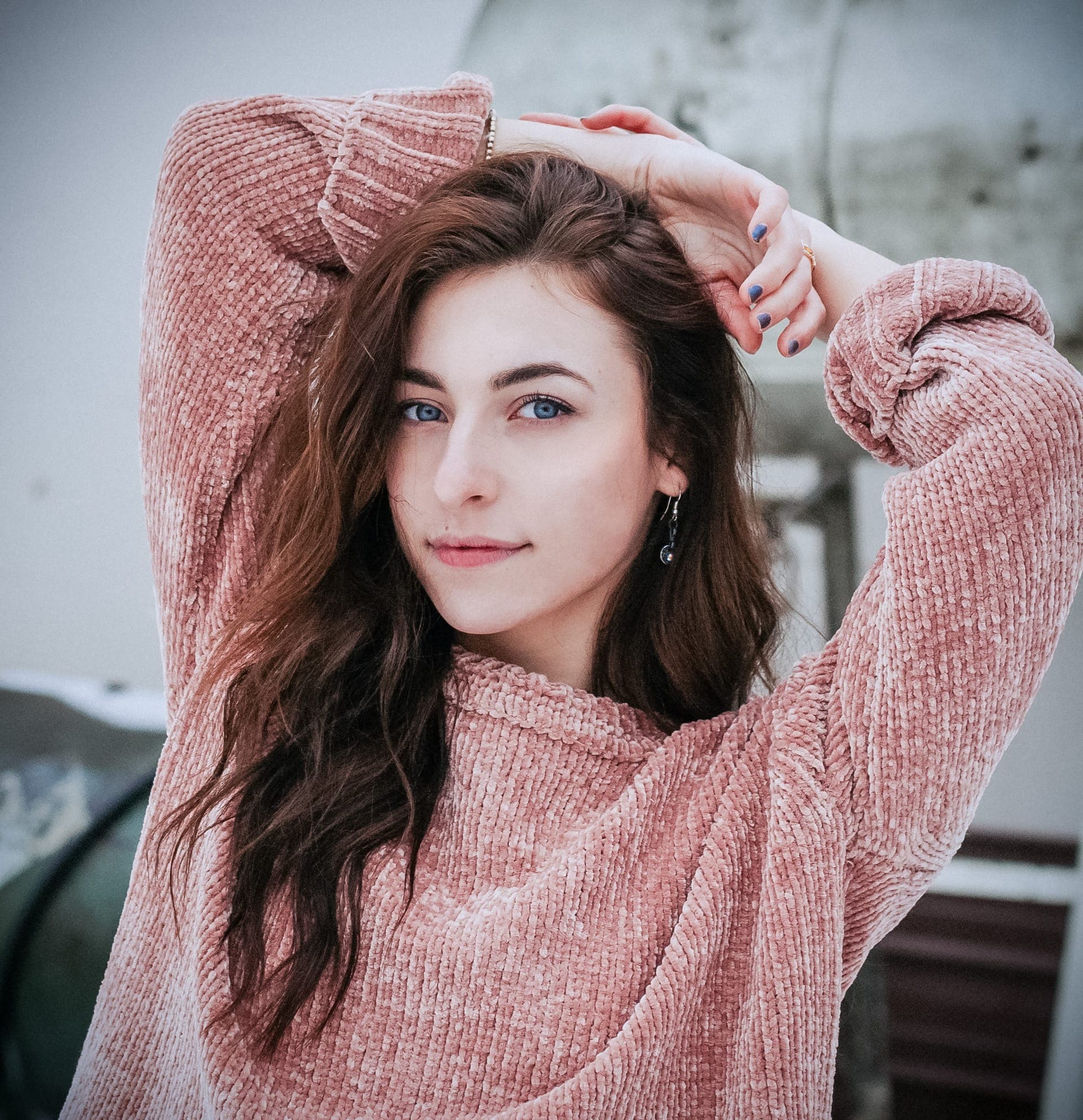Woman smiling at camera both hands on head.
