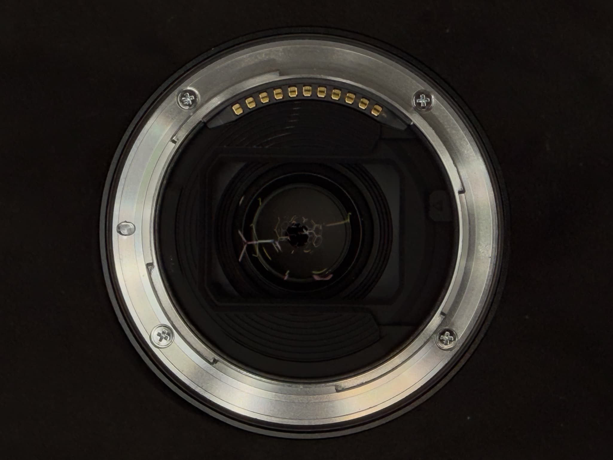 Clean close-up of the metal Z-mount flange face of the Nikon Z 14-24mm f/2.8 S, focusing on the pristine gold electronic communication pins