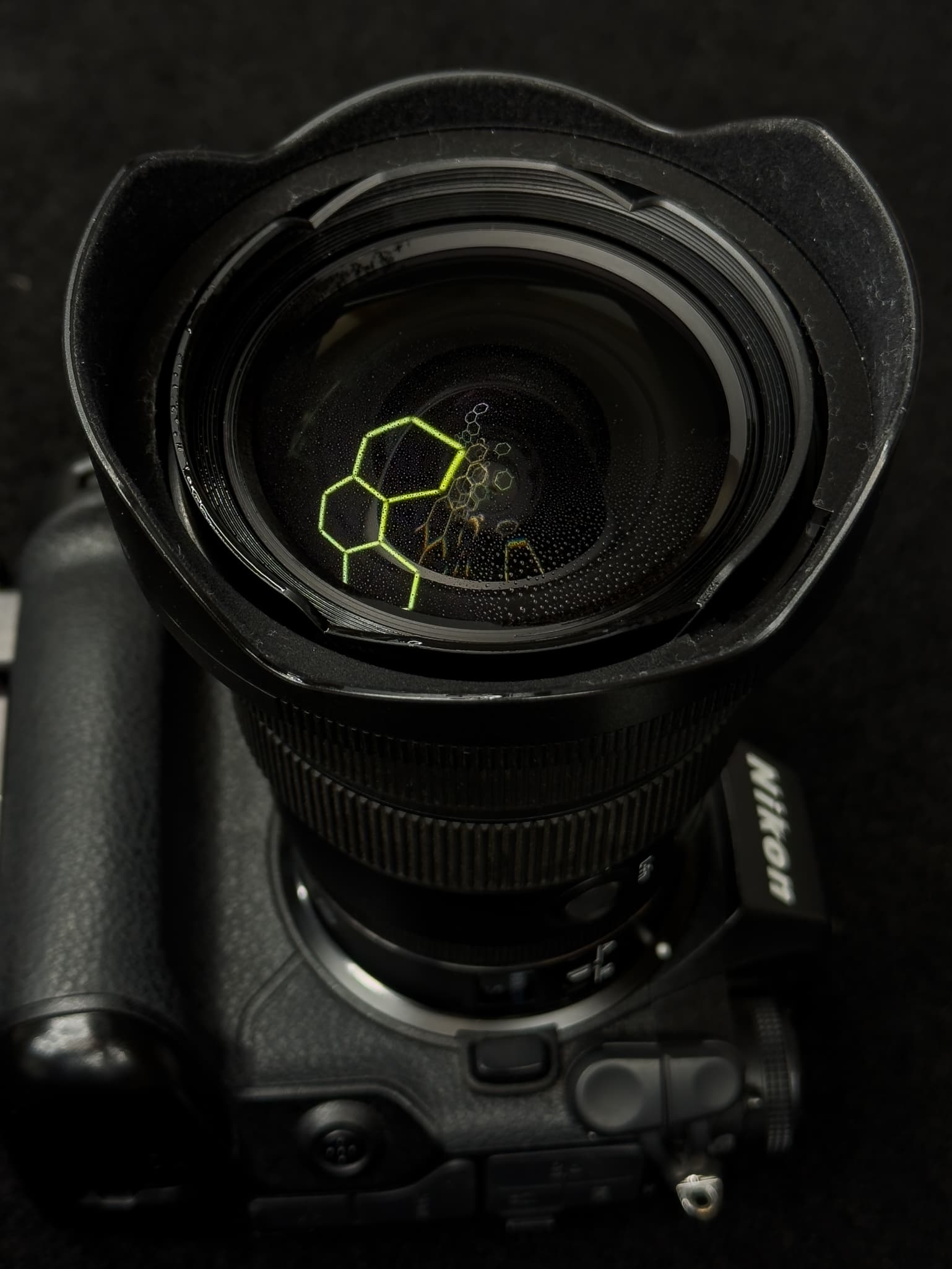 Accent shot highlighting the fluorine coat shedding water droplets or dust on the front glass element of the Nikon Z 14-24mm f/2.8 S
