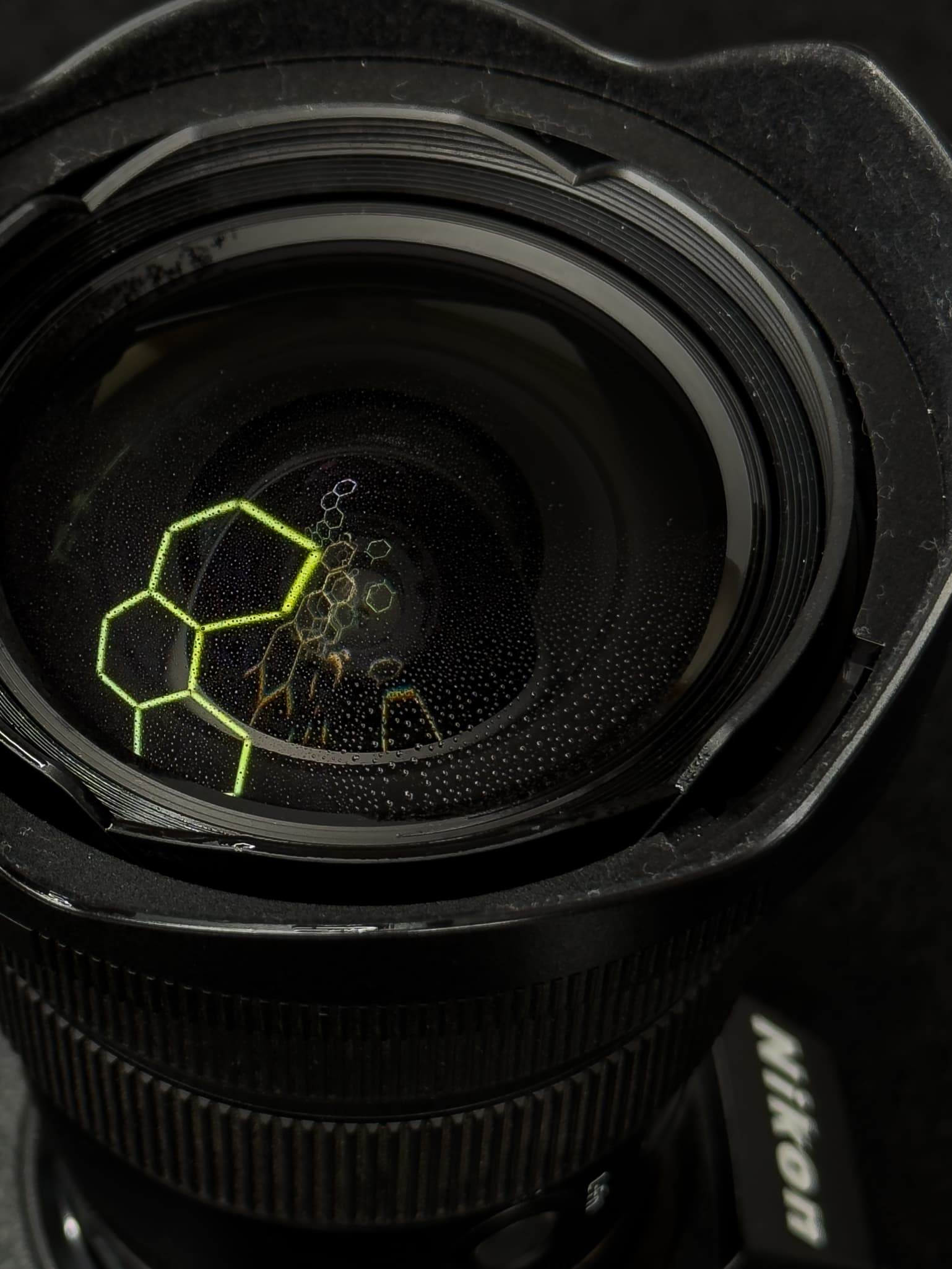 Accent shot highlighting the fluorine coat shedding water droplets or dust on the front glass element of the Nikon Z 14-24mm f/2.8 S