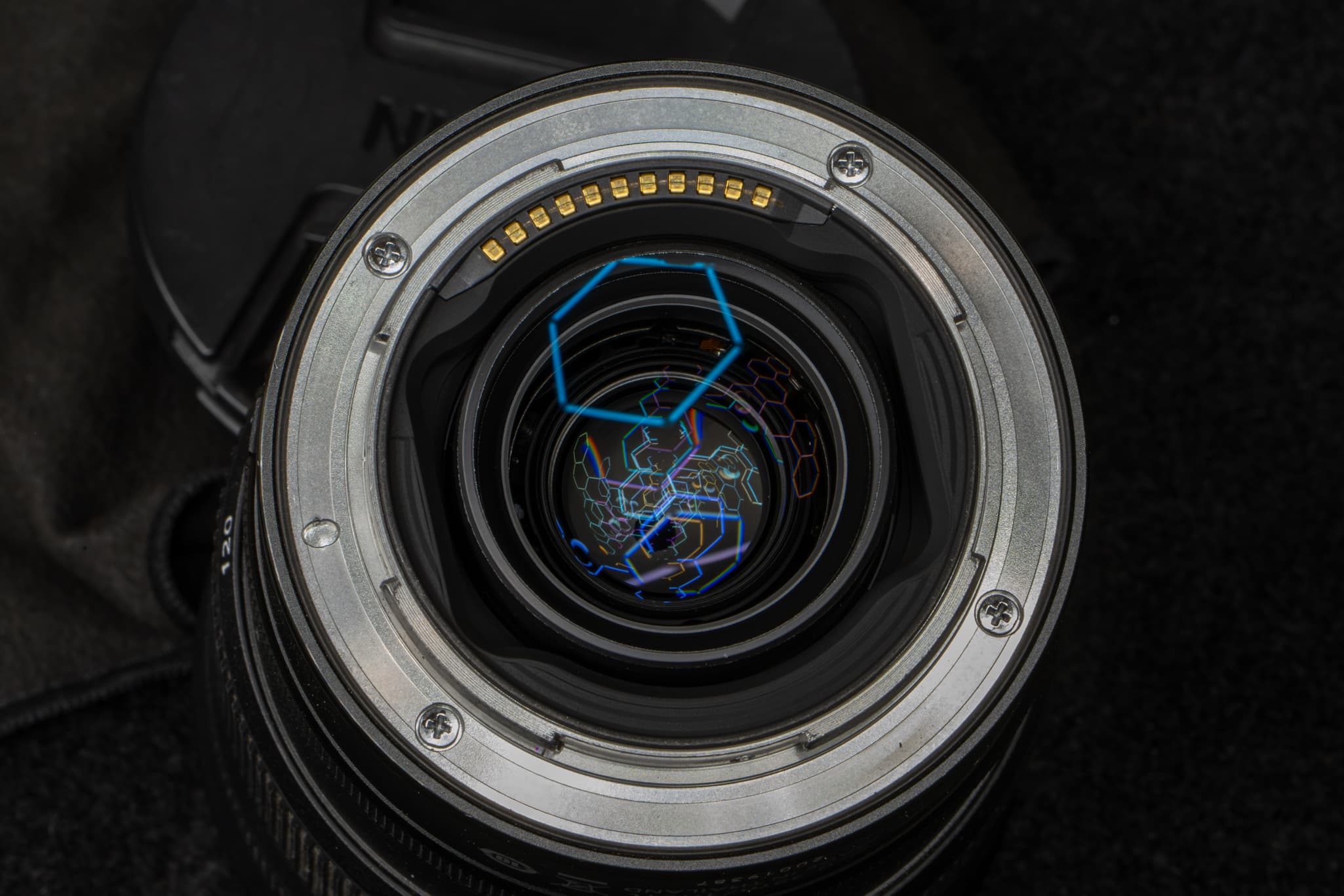 Clean close-up of the robust, machined metal lens mount flange, focusing on the gold electronic communication pins on the Nikon Z 24-120mm f/4 S