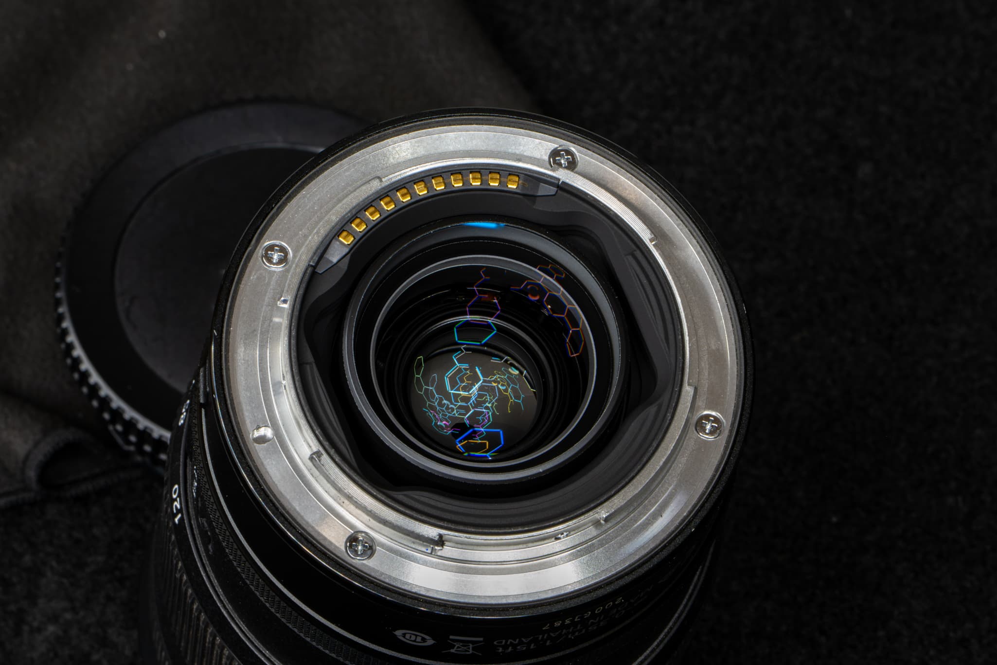 Clean close-up of the robust, machined metal lens mount flange, focusing on the gold electronic communication pins on the Nikon Z 24-120mm f/4 S