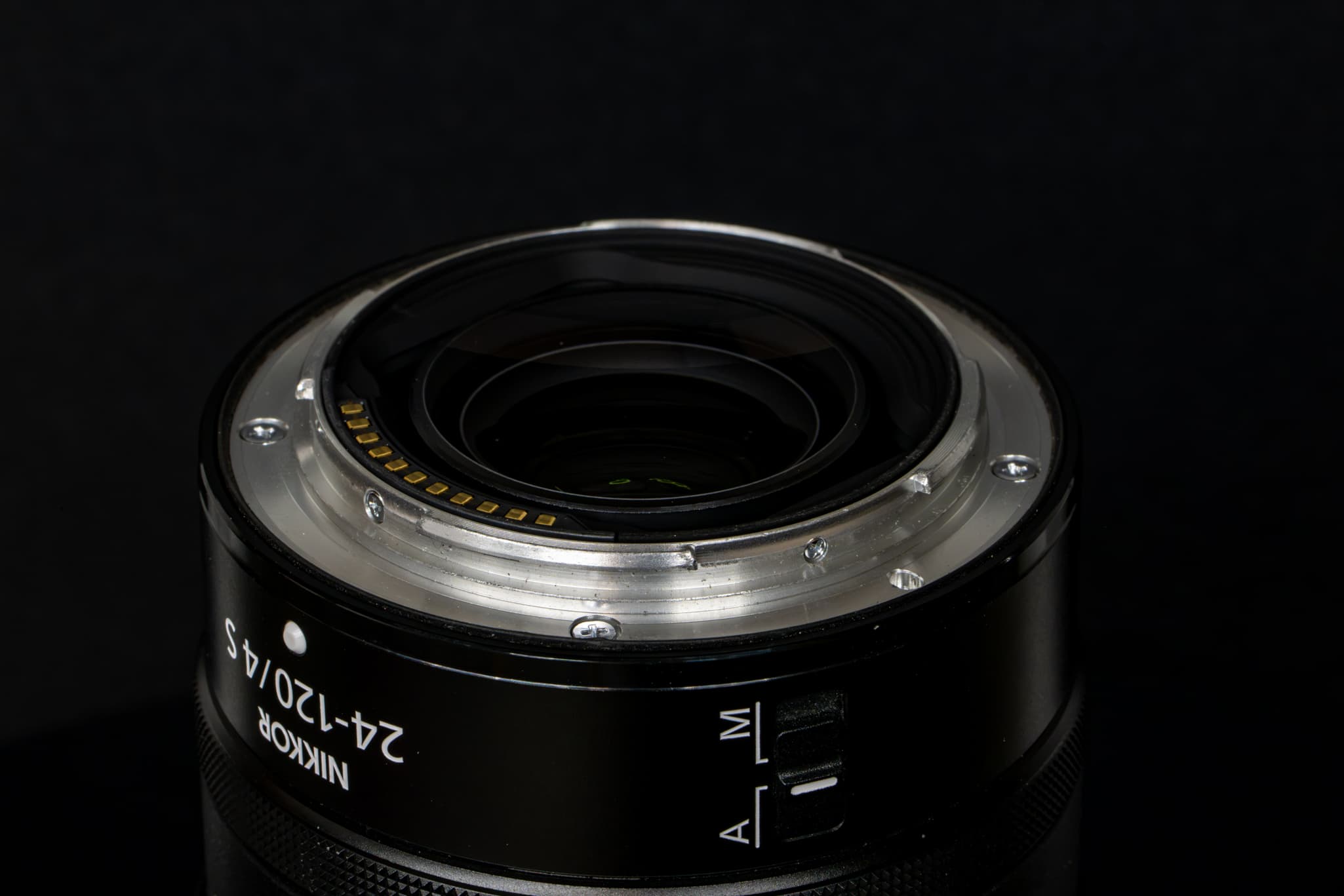 Close-up focusing directly on the rear metal mount interface of the Nikon Z 24-120mm f/4 S, highlighting the thick, prominent black rubber weather-sealing gasket designed to keep dust, moisture, and debris out of the camera sensor chamber