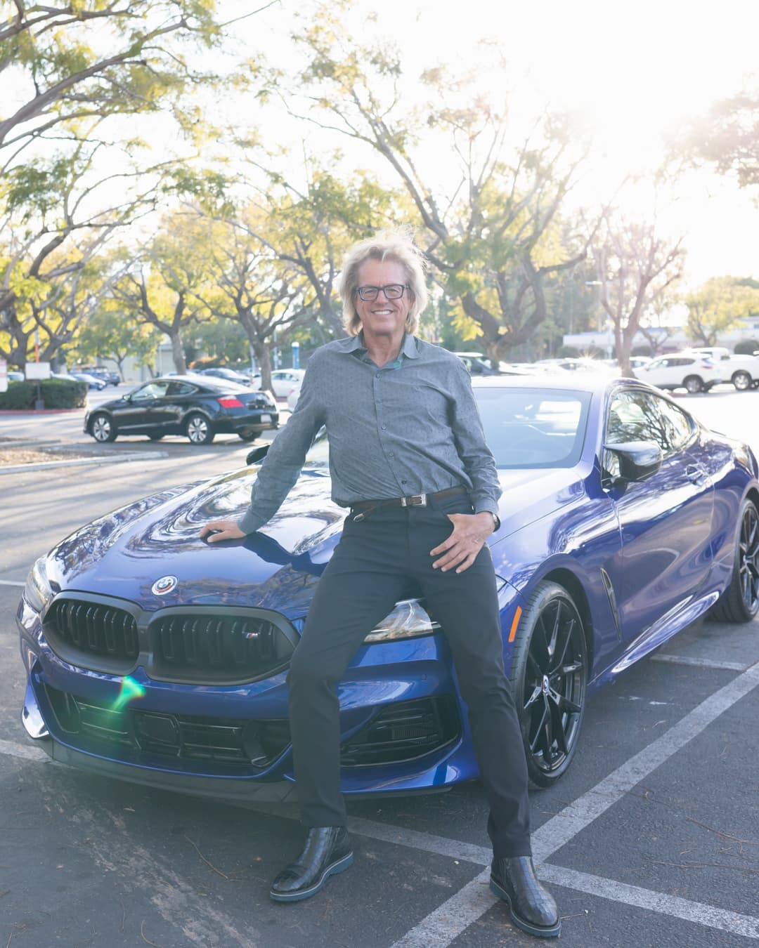 Man sitting on car in an overexposed photo.