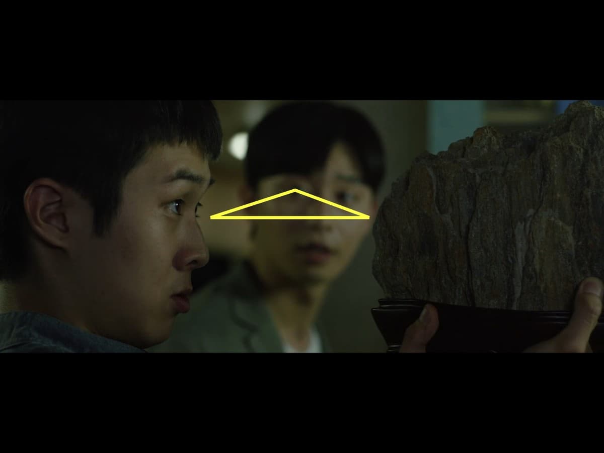 Composition from scene from Parasite where Ki-Woo is gifted scholar's rock.