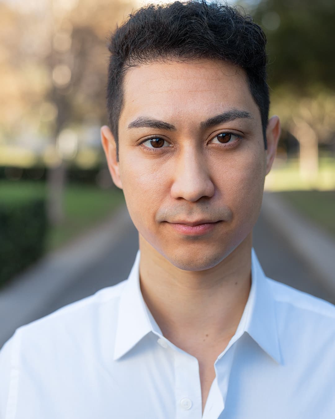 Man standing in park with shallow depth of field background.