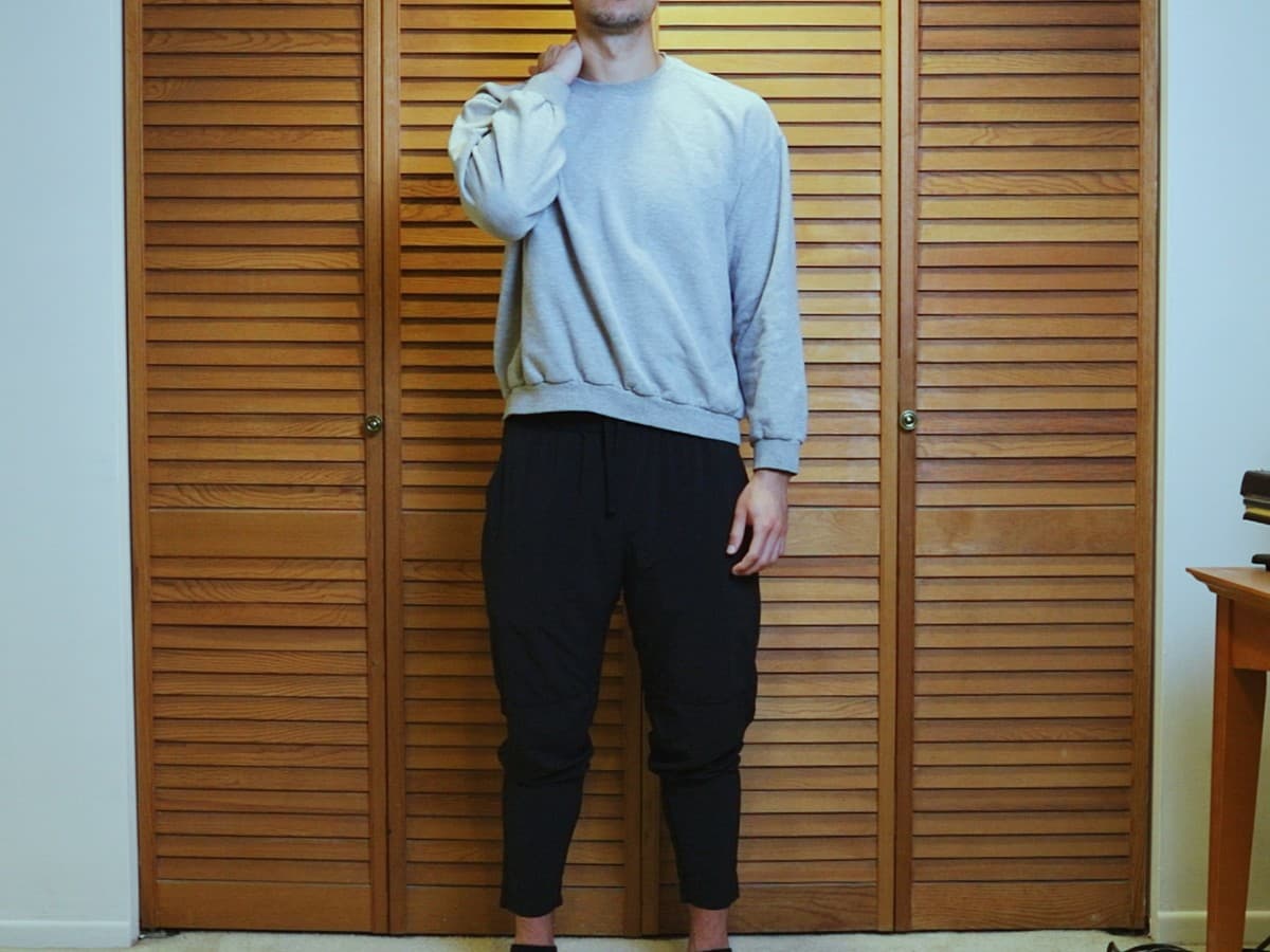 Man posing by putting hand behind neck.
