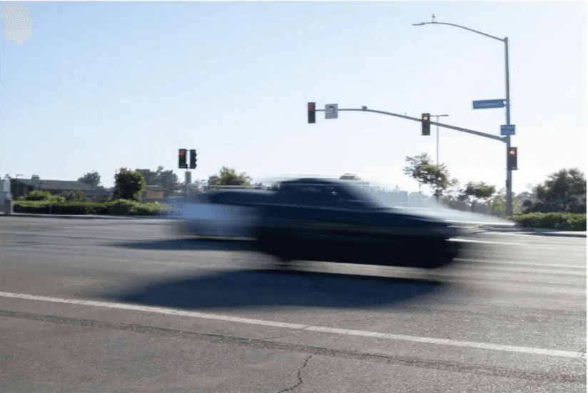 Cars blurred on road due to a slower shutter speed.