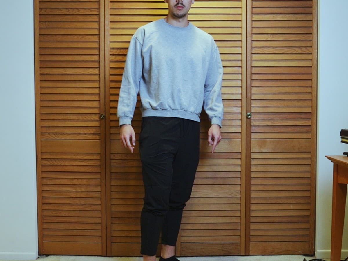 Man posing by standing and putting weight on back foot.