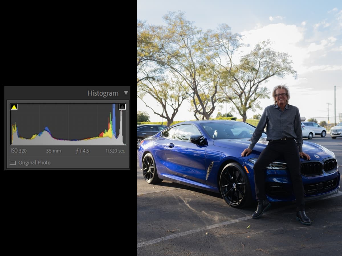 Man sitting on car in an underexposed photo.