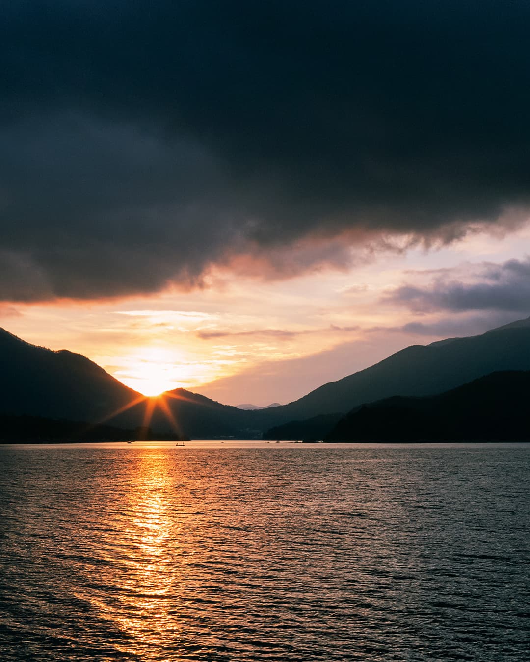 Lake in Japan with mountains in the background.