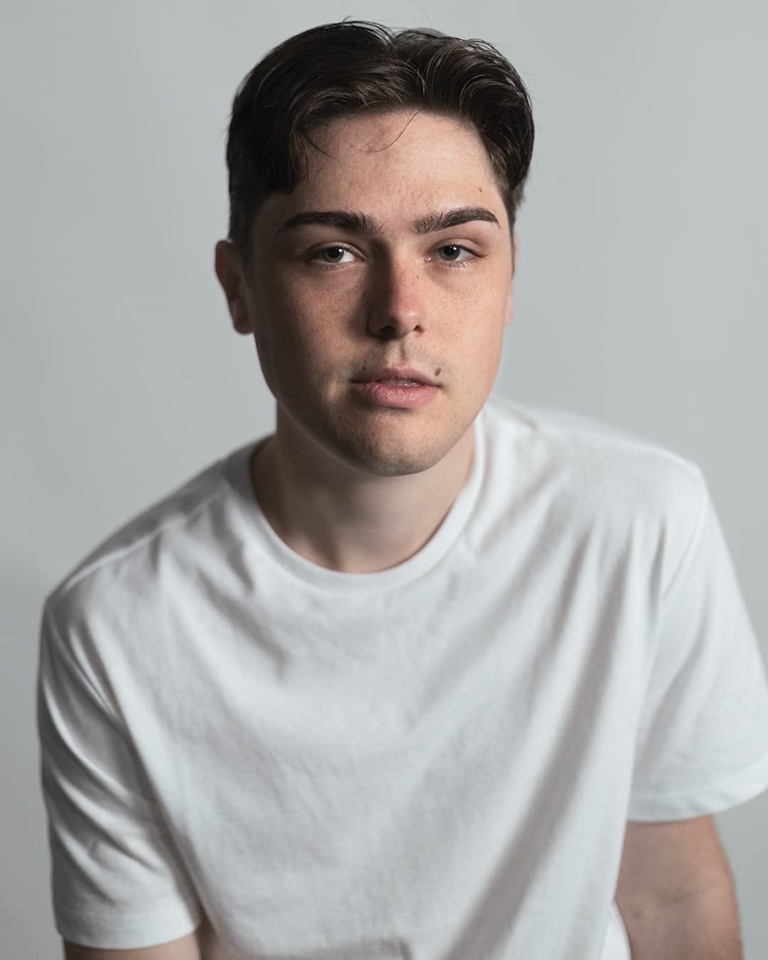 Man wearing neutral color white for his headshot.