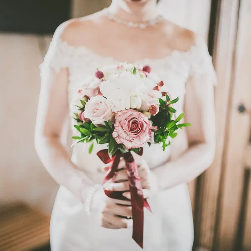 Woman holding bouquet of flowers.