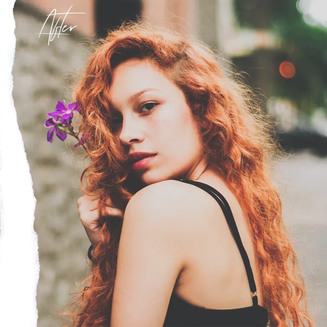 Red-haired woman looking over her shoulder at camera.