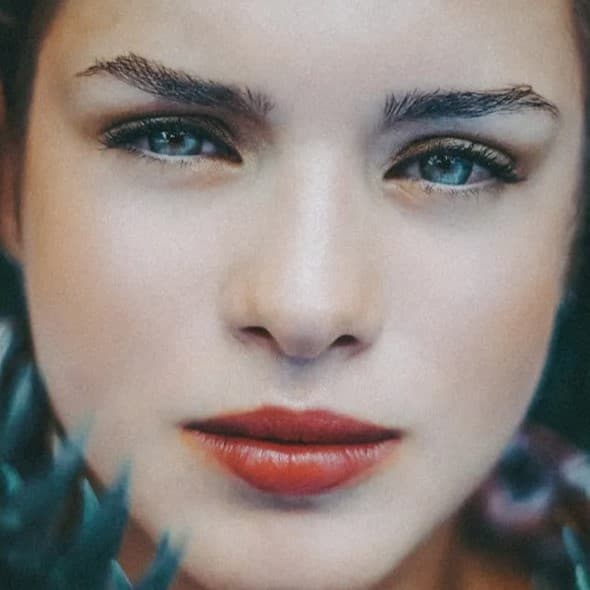 Woman looking at camera with a pensive look.