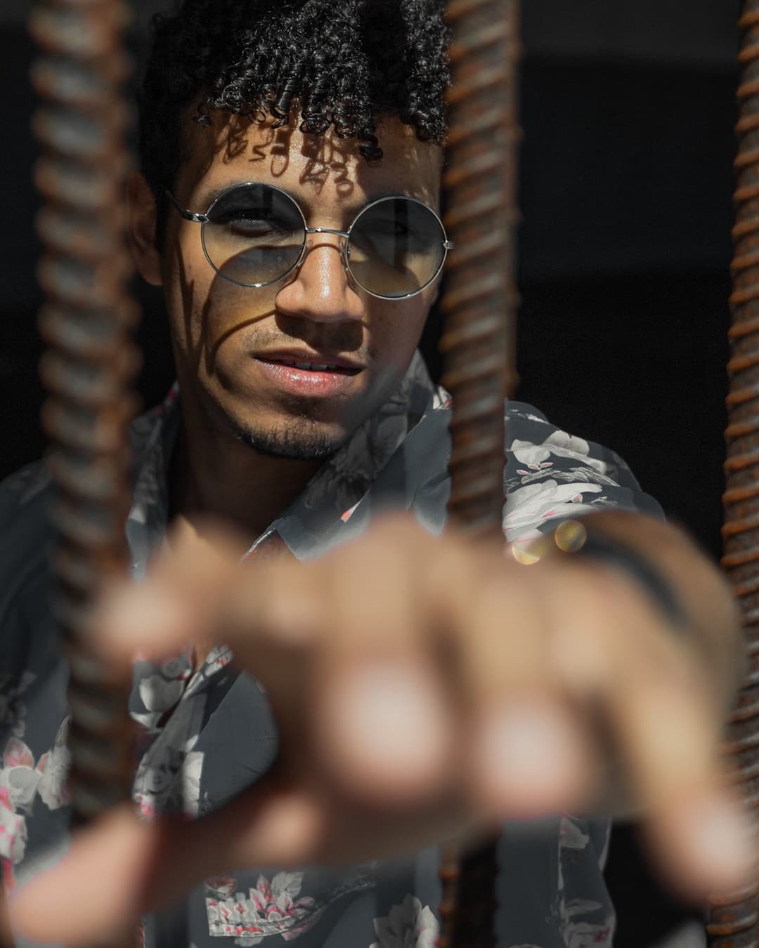 Subject before framing with bars Man reaching out to camera in between bars.