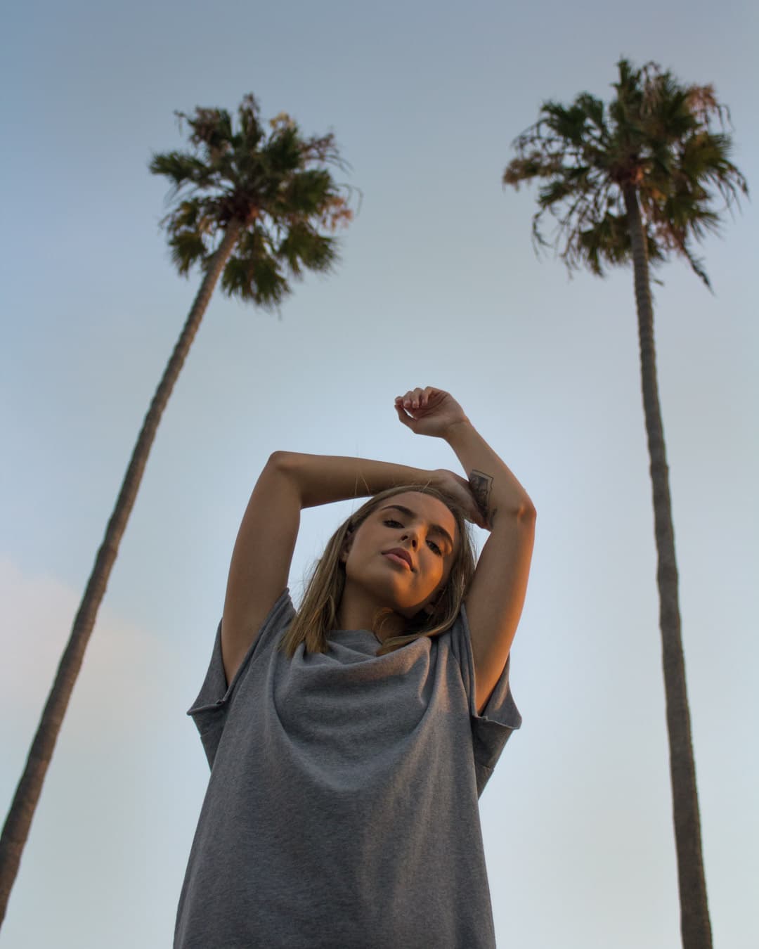 Subject standing between two palm trees Girl standing between two palm trees.