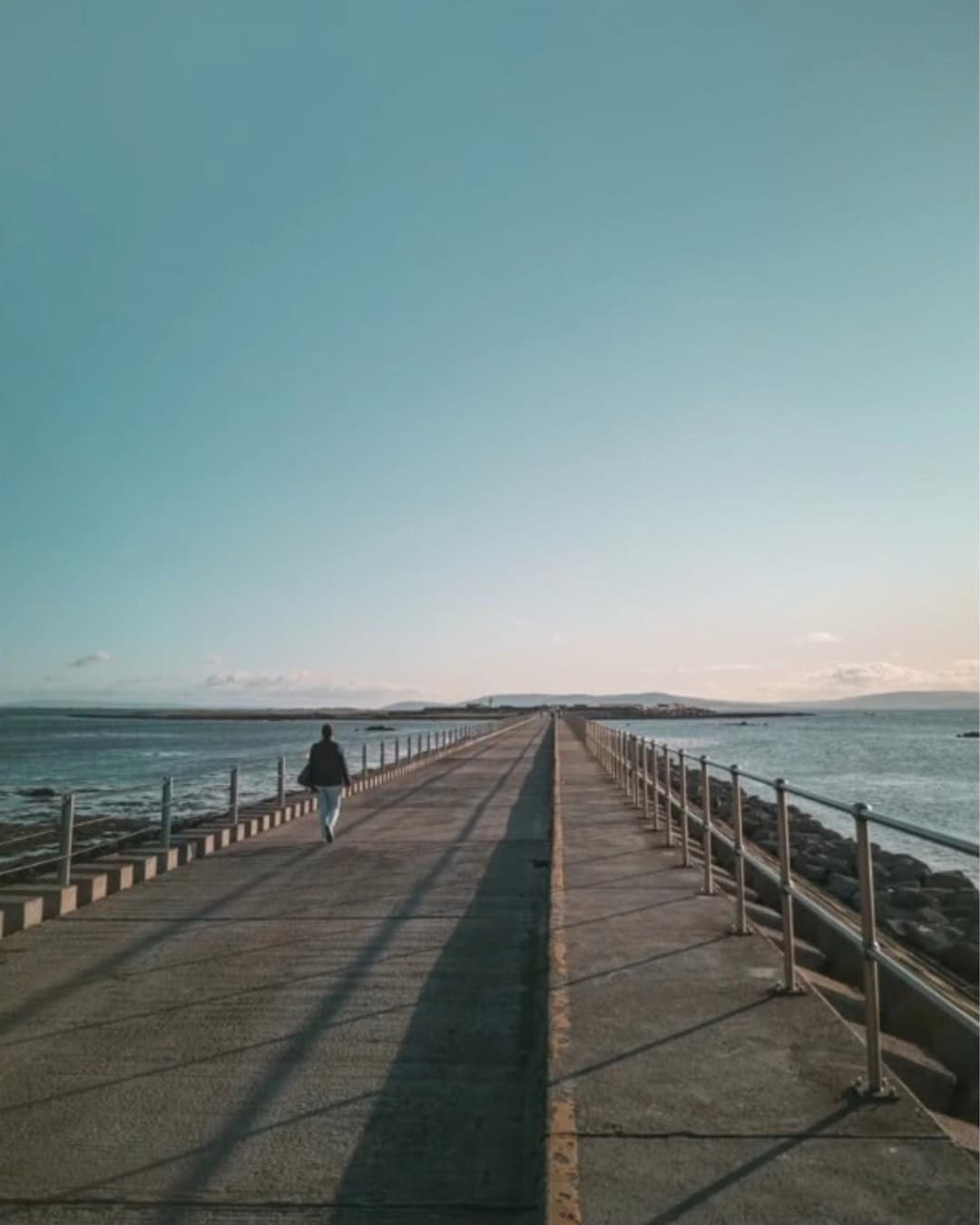 Before triangles Woman walking down bridge.