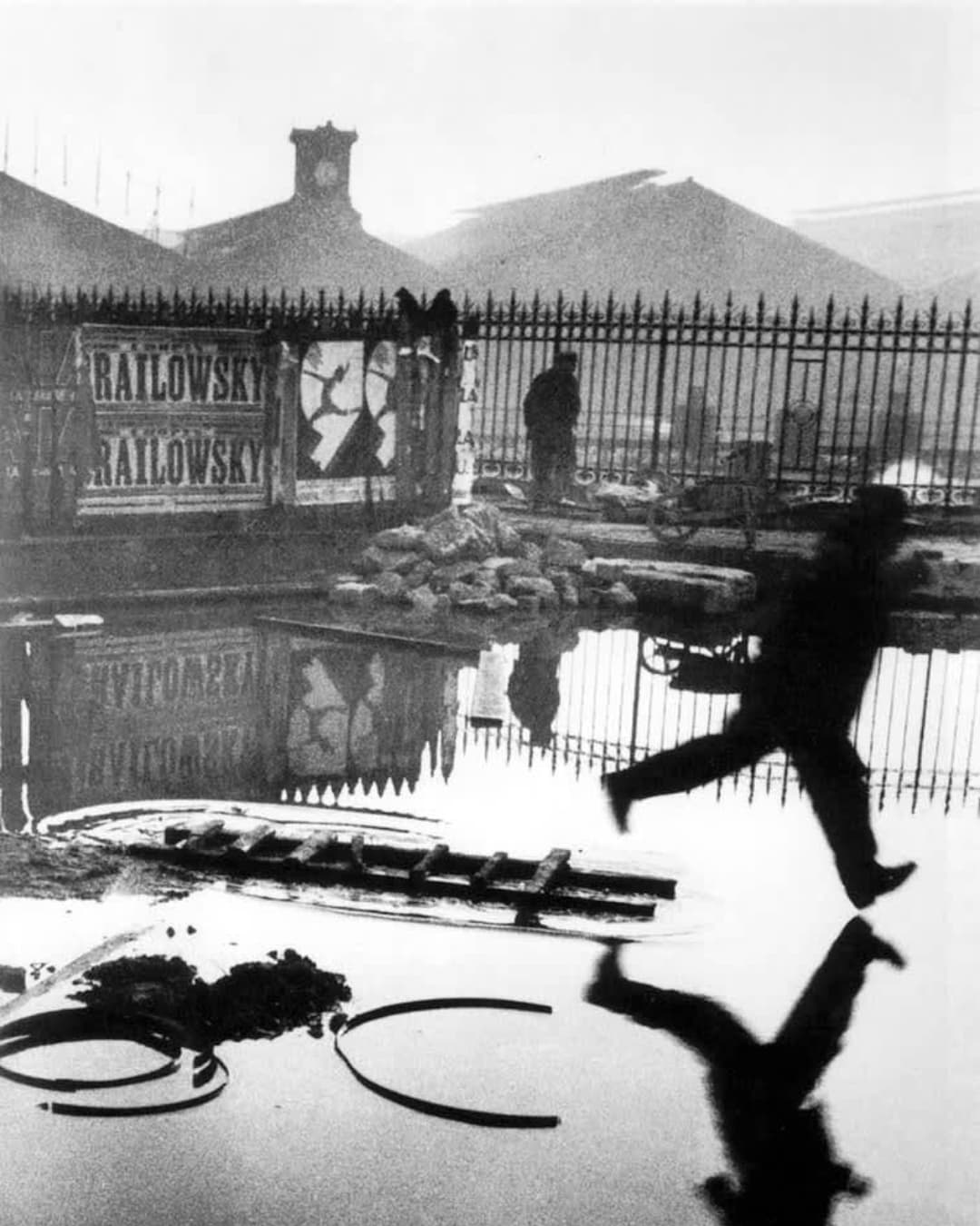 Henri Cartier-Bresson, Behind the Gare Saint-Lazare Using Framing Man jumping over a puddle.