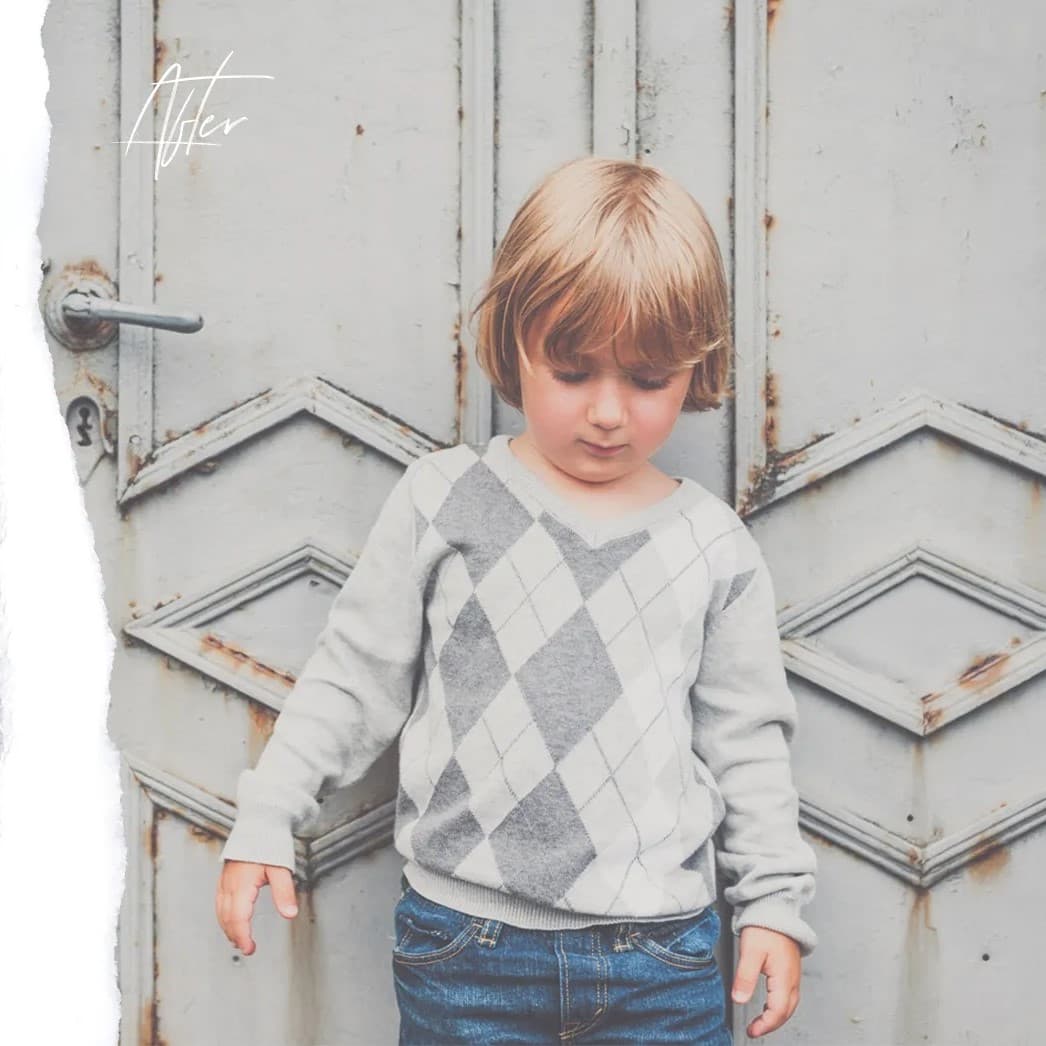 Little blonde boy in front of door.