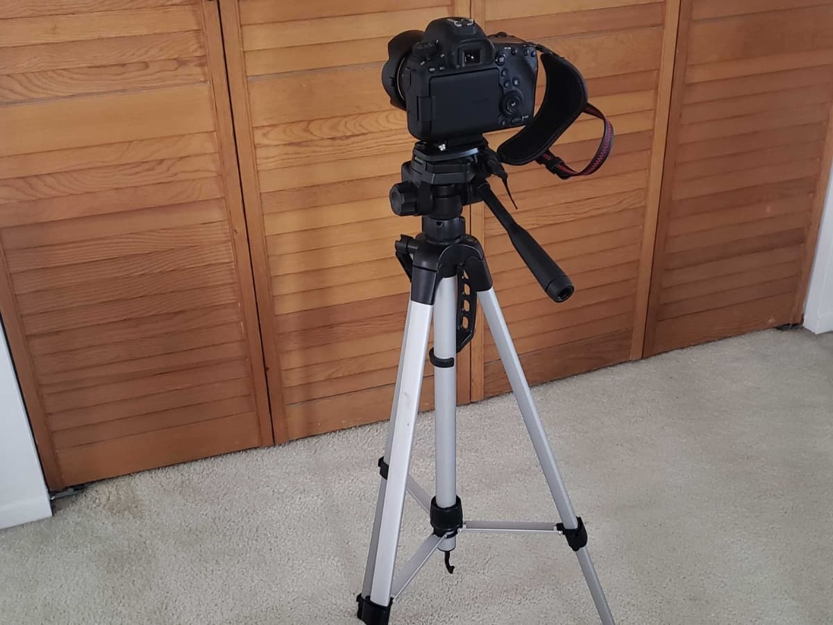 Camera on tripod for stabilization for sharp photos Camera on a tripod on rug.