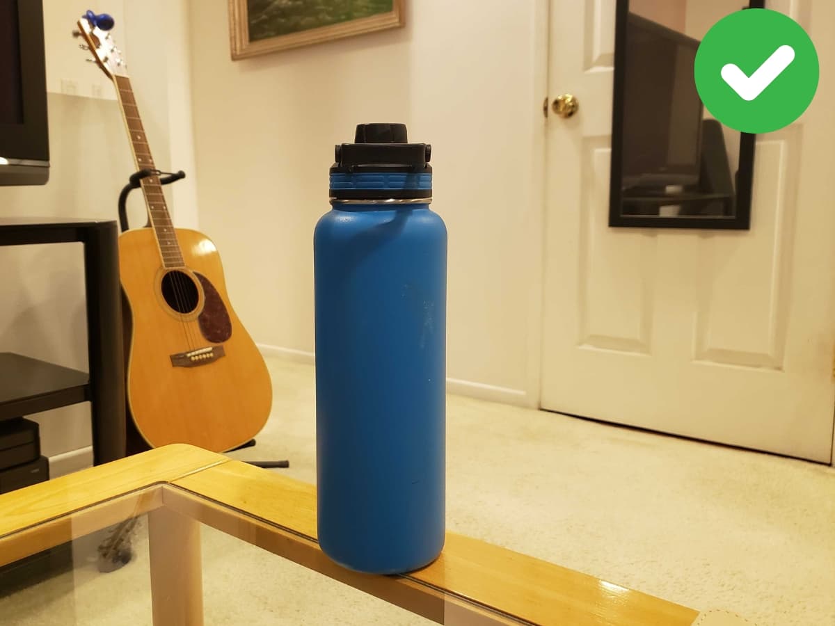 Correctly framing on all sides Water bottle resting on table.