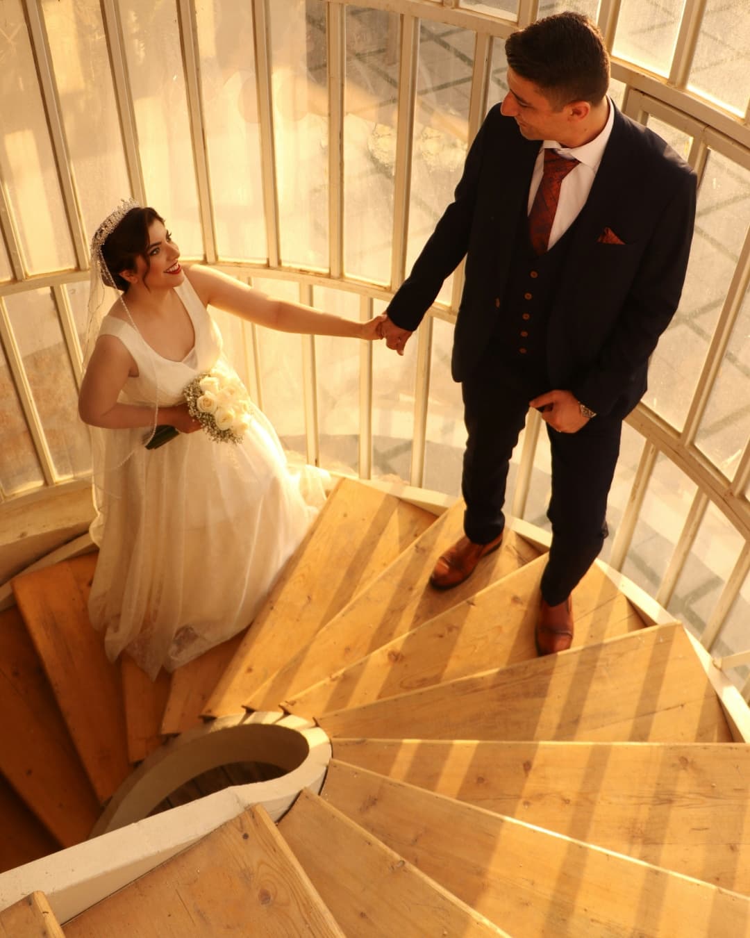 Leading line for storytelling Woman walking with groom up curved leading line staircase.