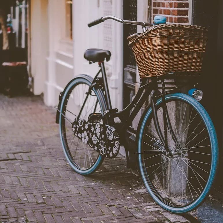 Blue bike leaning against wall.