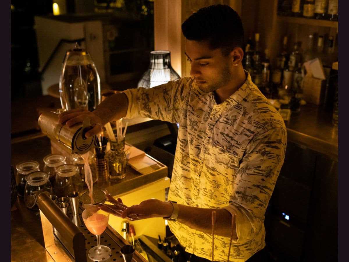 Environmental portrait Man bartending pouring drinks in an environmental portrait.