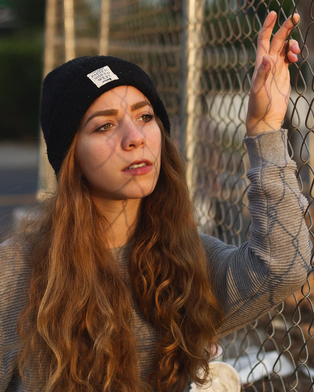Subject framed between fence lines Girl holding onto fence being framed by fence lines.