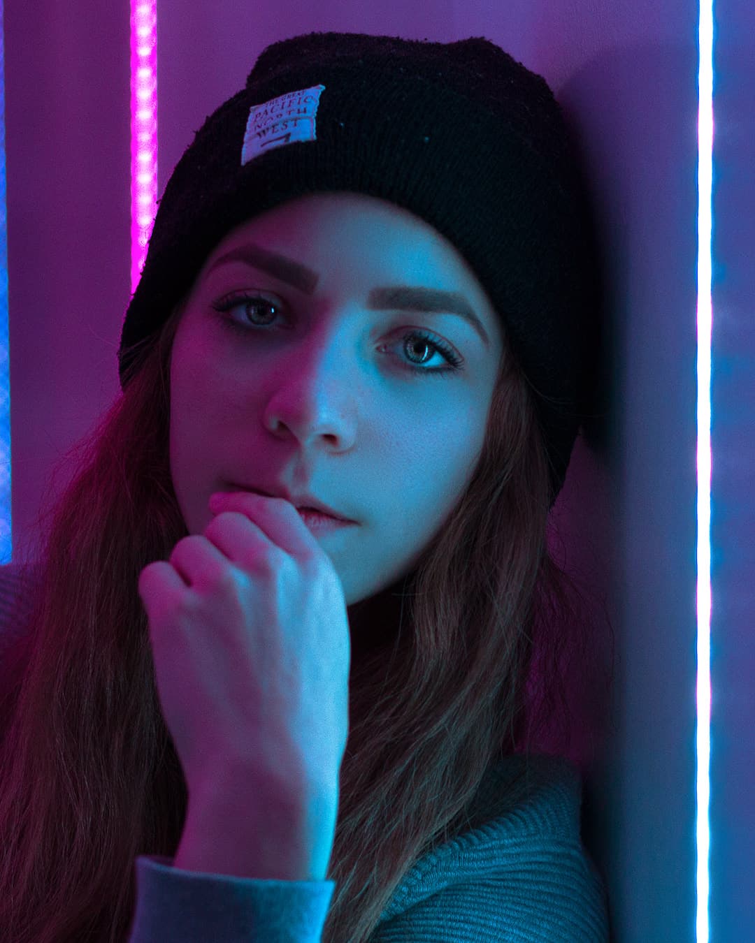 Framing in between two neon light strips Female sitting between two neon light strips.