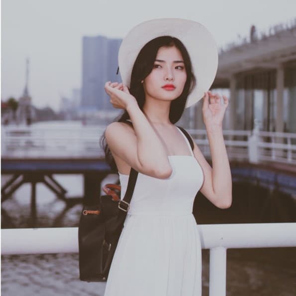 Woman with black backpack and white dress.
