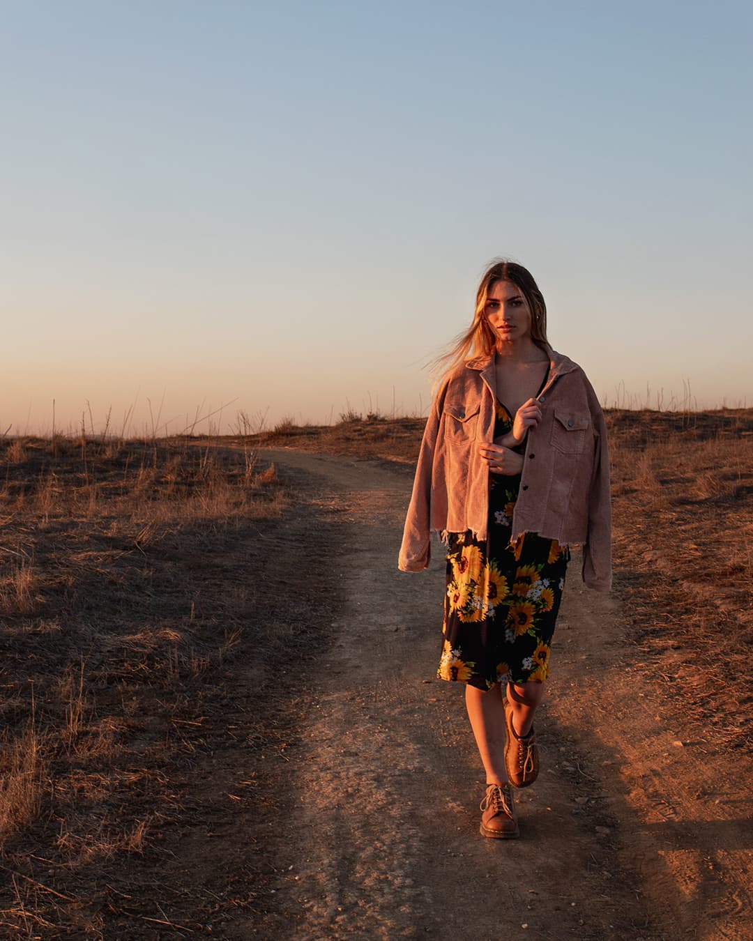 Portrait with golden hour ambient light Woman walking down path with golden hour ambient light on her.