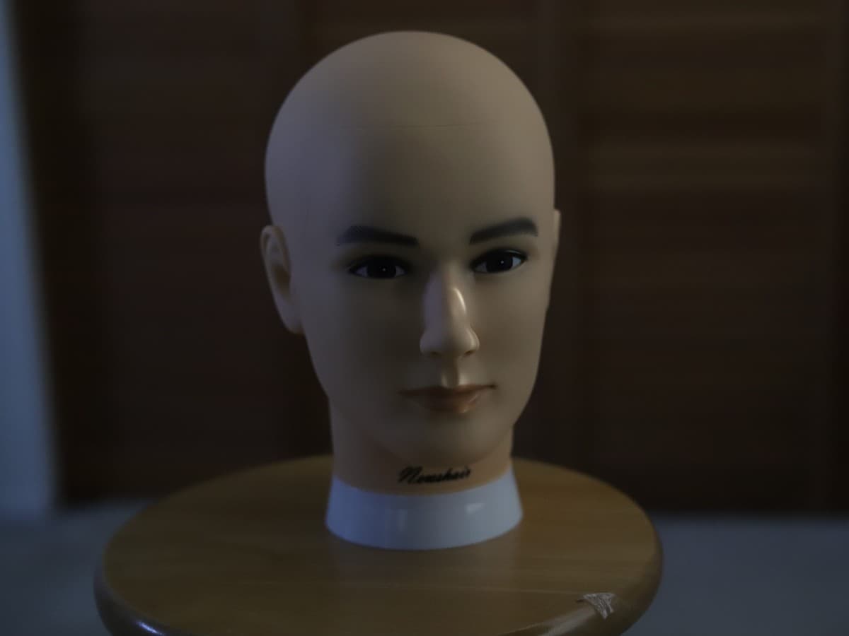 Image no window light Mannequin head on stool dark because there is no window light.
